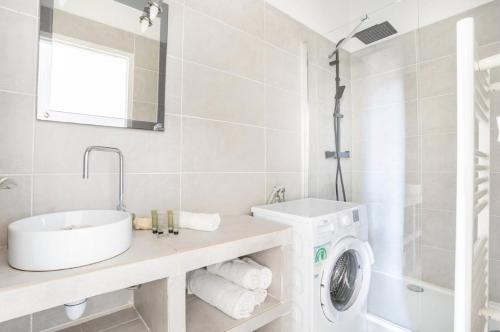 une salle de bain avec un lavabo et une machine à laver dans l'établissement Appartement cosy au coeur du panier, à Marseille
