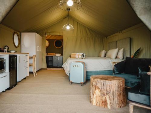 a bedroom in a tent with a bed and a couch at Longhill Reserve in Addo
