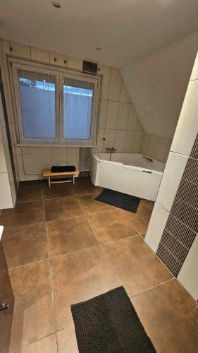 - une grande salle de bains avec baignoire et 2 fenêtres dans l'établissement Strasbourg village proximité des marchés de Noël, à Herrlisheim