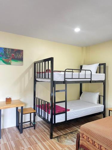 a room with two bunk beds and a table at Anawin Bungalows in Ao Nang Beach