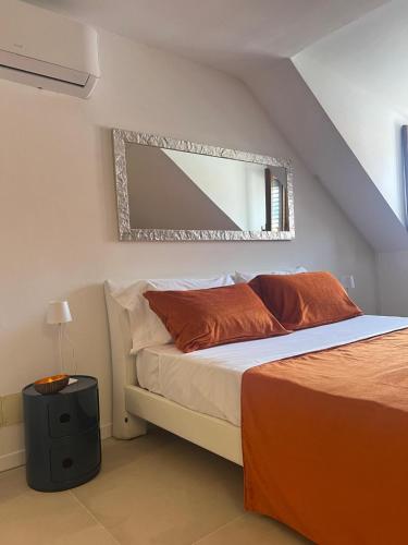 a bedroom with a bed with a mirror on the wall at Domus Orestea Luxury Suites in Palermo