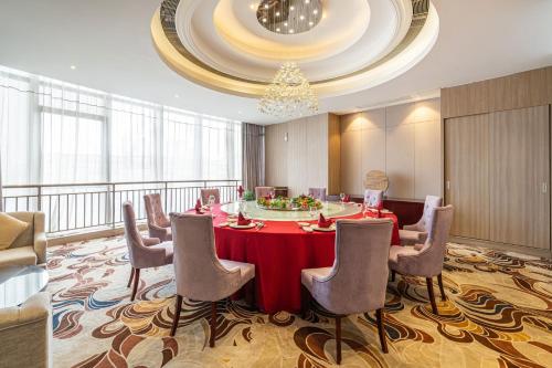 a conference room with a red table and chairs at Days Hotel Suzhou in Suzhou