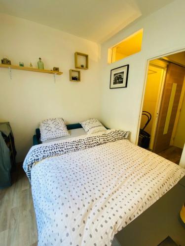 une chambre avec un lit avec une couette blanche dans l'établissement Appartement Studio cosy 17ème, à Paris