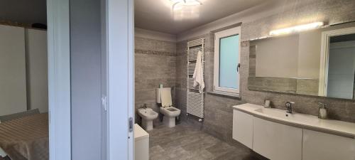 a bathroom with a toilet and a sink and a mirror at Villa Fiorita in Avigliana
