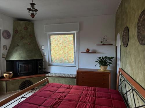 a bedroom with a bed and a window and a stove at Casa Augusto ai Berici, con Idromassaggio e Sauna in Arcugnano