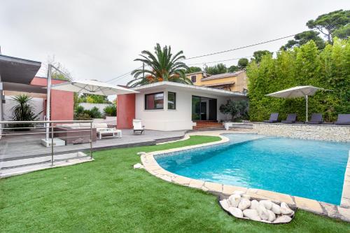 une cour arrière avec une piscine et une maison dans l'établissement Villa Rainbow · Maison dArchitecte, à Marseille