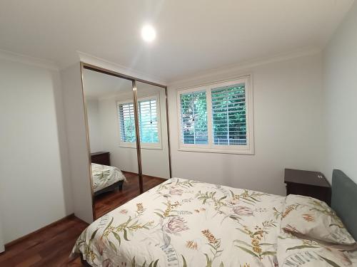a bedroom with a bed and a mirror at Cozy Room in Modern and Peaceful Home - BH5 in Baulkham Hills