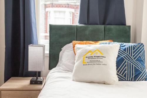 a bed with a pillow on it with a window at Modern 5-Bedroom House with 8 Beds, Perfect for Contractors, Extended Stay Savings in Wallasey