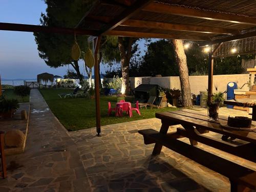 a patio with a wooden picnic table in a yard at Pampas Seafront villa, 6 bedrooms, North Evvoia in Kanatádhika