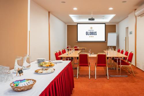 a conference room with tables and chairs and a screen at Hotel Globus in Prague
