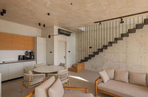 a living room with a table and chairs and a staircase at Greenvale Park Villas by Coastalbliss in Khlorakas