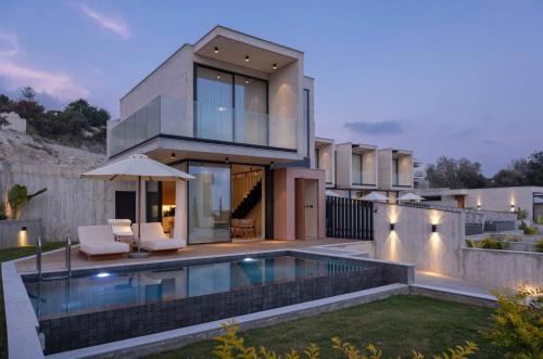 a house with a swimming pool in front of it at Greenvale Park Villas by Coastalbliss in Khlorakas