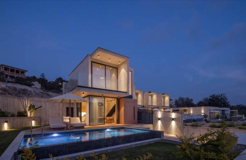 a house with a swimming pool at night at Greenvale Park Villas by Coastalbliss in Khlorakas