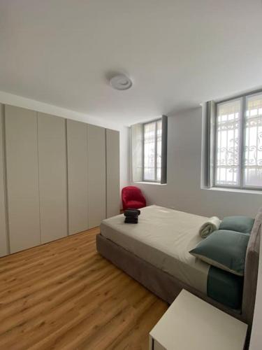 a bedroom with a bed and a red chair at Bilocale centro storico in Novara