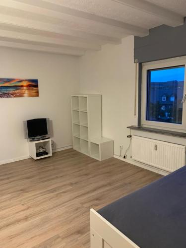 a white room with a tv and a large window at Fewo Meschede Eversberg Radring in Meschede