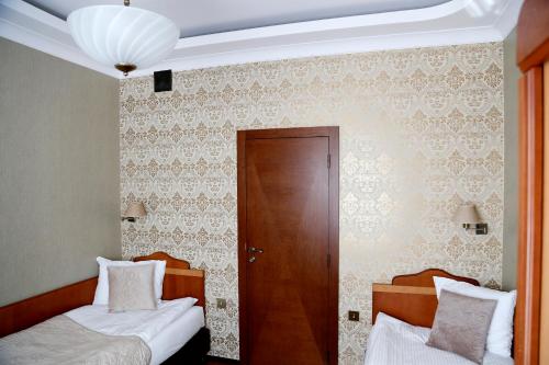 a bedroom with two beds and a wooden door at Villa Solankowa in Inowrocław