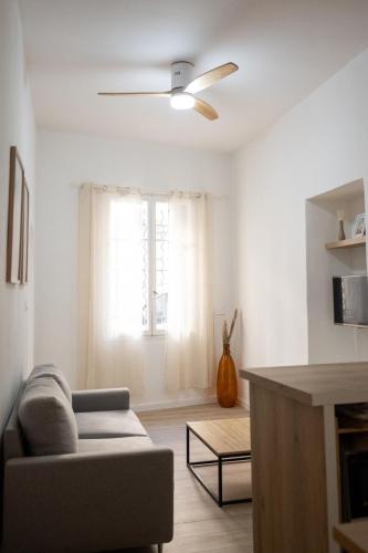 アルルにあるBel appartement proche arènesのソファと天井ファンのあるリビングルーム
