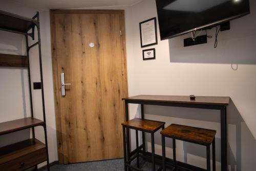 a room with a wooden door and two stools at Dream Aparts - Wschodnia 34 in Łódź