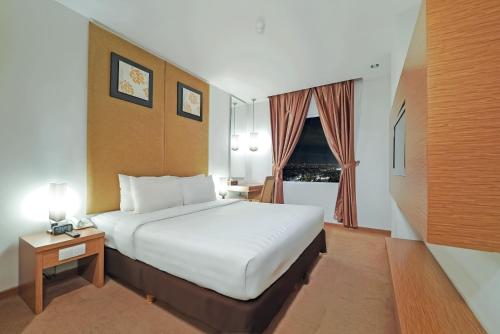 a hotel room with a bed and a window at Grand Tjokro Yogyakarta in Yogyakarta