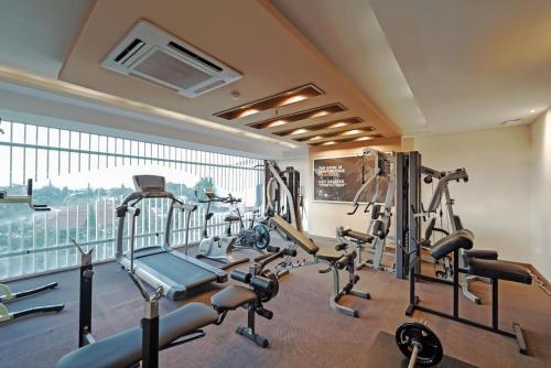 a gym with cardio equipment and a large window at Grand Tjokro Yogyakarta in Yogyakarta