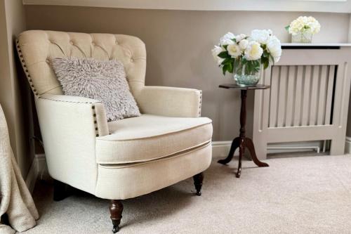 a white chair with a vase of flowers on a table at Winsor Croft in Southampton
