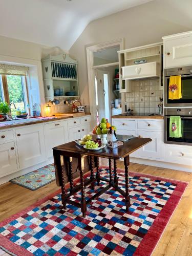 a kitchen with a table with a bowl of fruit on it at Hideaway at Foxhollow in Kells