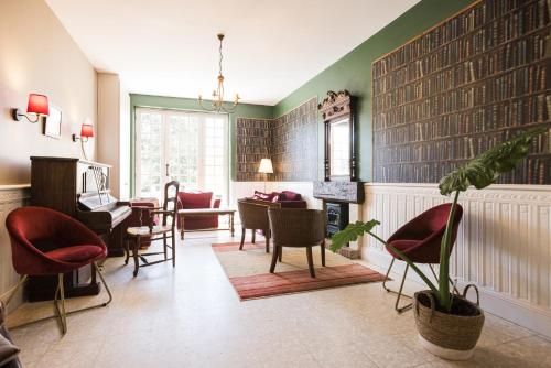 a living room with chairs and a table and a fireplace at Logis Hôtel Restaurant Le Lascaux in Montignac