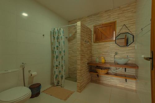 ein Badezimmer mit Dusche, Toilette und Waschbecken in der Unterkunft Chalés Samambaia 1 in Bananeiras