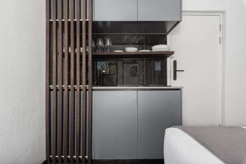 eine Küche mit weißen Schränken und einer Arbeitsplatte in der Unterkunft Calais Heritage House Apartments in Kapstadt