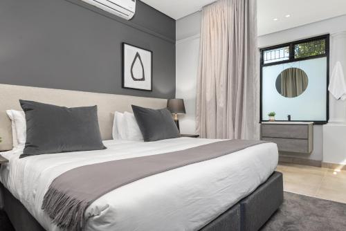 ein Schlafzimmer mit großem Bett und Fenster in der Unterkunft Calais Heritage House Apartments in Kapstadt