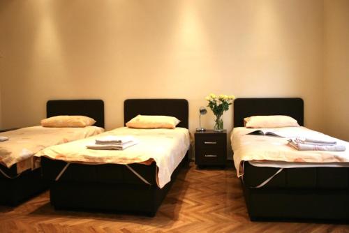 Habitación con 2 camas y un jarrón de flores en Belgrade Stay Apartments, en Belgrado