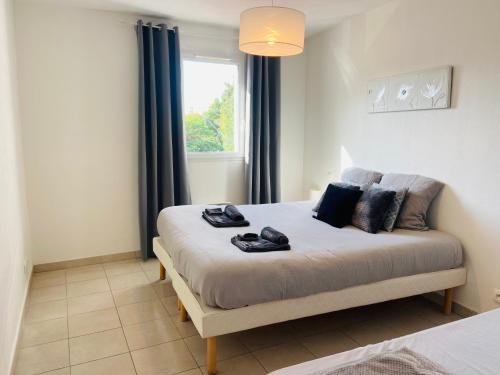 une chambre avec un lit avec deux chaussures dessus dans l'établissement Appartement très lumineux au cœur du massif de la Sainte Baume, à Plan dʼAups