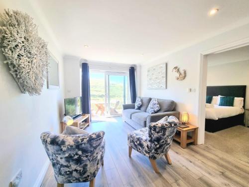 a living room with a couch and a chair at Beachcombers Apartments in Newquay
