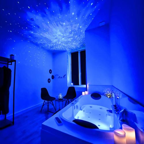 Cette chambre bleue est dotée d'une baignoire et d'étoiles au plafond. dans l'établissement Cinéma & Jacuzzi aux Étoiles - CasaBianca Suite, à Saint-Étienne