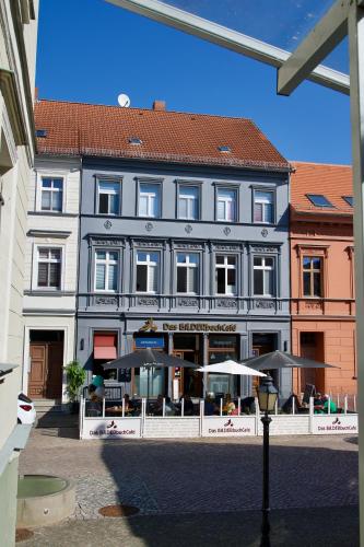 a large building with umbrellas in front of it at Das BilderbuchCafe - Pension Markt 7 in Havelberg