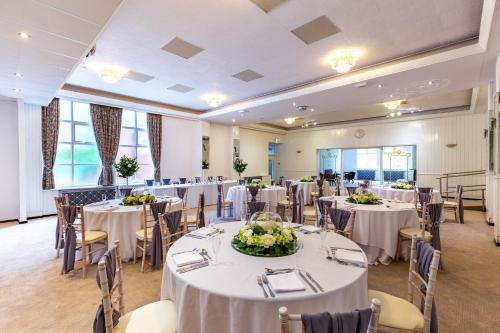 a banquet room with tables and chairs with white tablecloths at Alma Lodge Hotel in Stockport