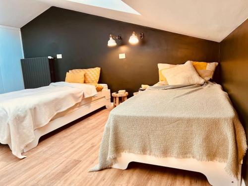 a bedroom with two beds and a black wall at Charme e Tranquillità in Montagna in Rocca di Mezzo