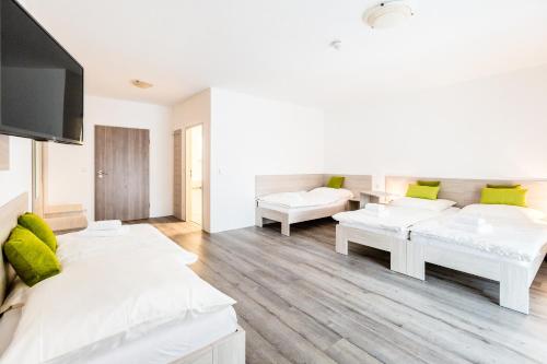 a living room with white furniture and green pillows at Hotel Anna Hilden in Hilden