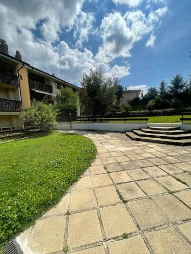 a courtyard with a building and some grass and stairs at Charme e Tranquillità in Montagna in Rocca di Mezzo
