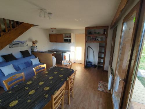 Pokój z łóżkiem i kuchnią ze stołem w obiekcie Chalet 6-8 couchages à la Joue du Loup w mieście Dévoluy