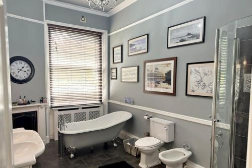 a bathroom with a tub and a toilet and a sink at The Retreat Averham in Kelham
