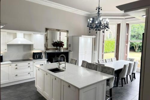 a kitchen with white cabinets and a table and a dining room at The Retreat Averham in Kelham