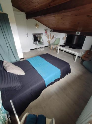 - une chambre avec un grand lit bleu et une télévision dans l'établissement Chambre et salle de bain, à Lescar