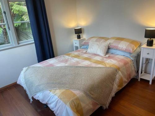 a bedroom with two beds and a window at Watts, A Cosy Escape in Hamilton