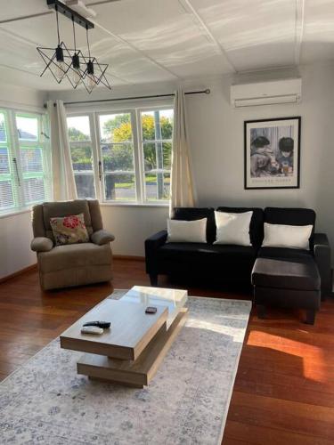 a living room with a couch and a coffee table at Watts, A Cosy Escape in Hamilton