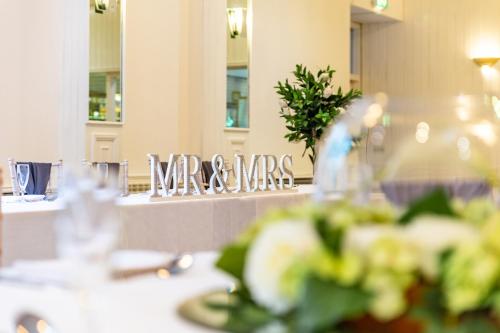 a table in a restaurant with a sign that says mews at Alma Lodge Hotel in Stockport