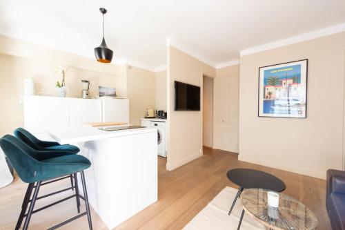 une cuisine et un salon avec un comptoir et des chaises dans l'établissement Cannes 1-Br Apartment Quiet Balcony, à Cannes