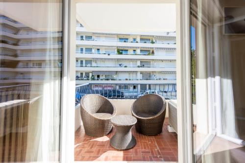 - un balcon avec deux chaises et une table dans l'établissement Cannes 1-Br Apartment Quiet Balcony, à Cannes