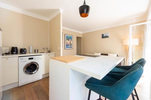 - une cuisine avec un comptoir blanc et un lave-linge dans l'établissement Cannes 1-Br Apartment Quiet Balcony, à Cannes