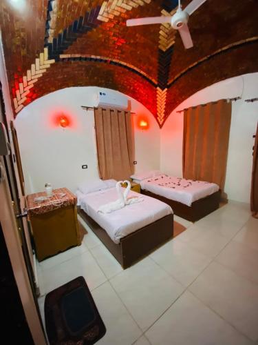 a room with two beds and a tv in it at Dangy Kato in Aswan